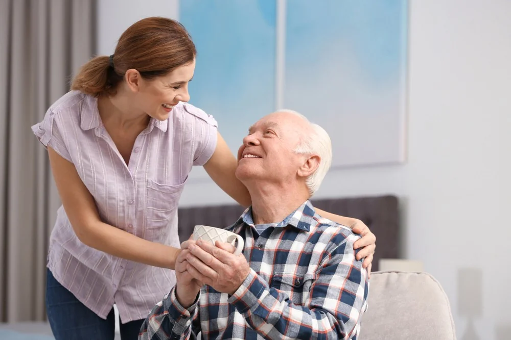 Pflegerin lacht mit Seniorin